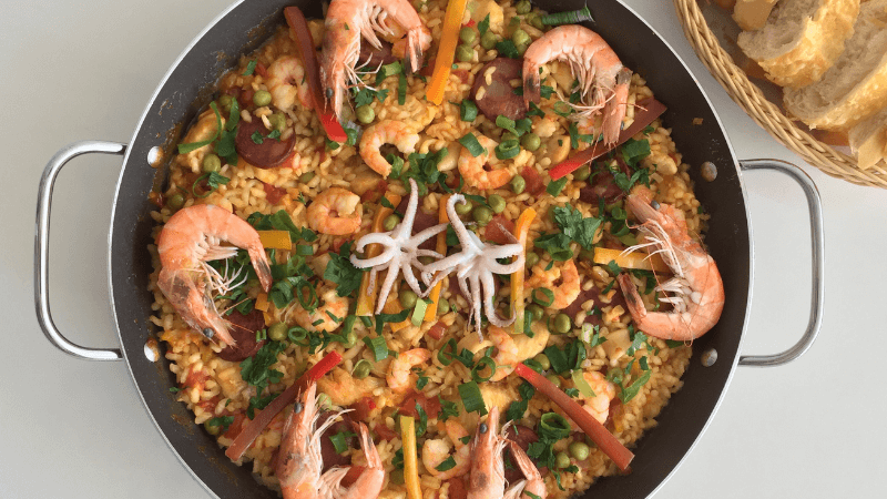 paella com frango e frutos do mar na chapa branca. prato espanhol